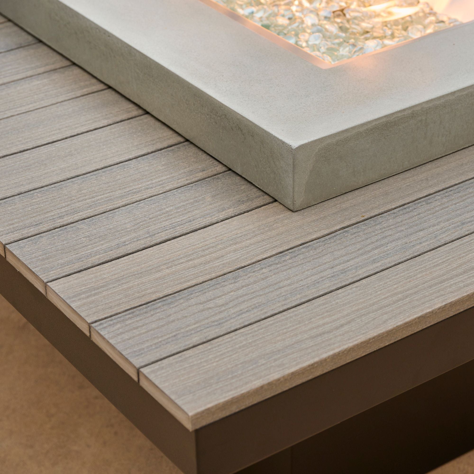 A close up of the lumber tabletop of the Uptown Coastal Grey Linear Gas Fire Pit Table