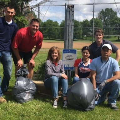Five Outdoor GreatRoom Company employees volunteering with a park cleanup project
