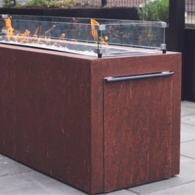 The side access door of a custom linear gas fire pit table with a glass wind guard on top