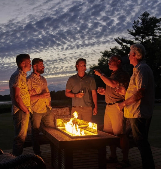 A group of friends standing around the Denali Brew Linear Gas Fire Pit Table