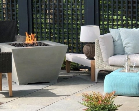 A Cove Square Gas Fire Pit Table next to some patio furniture and decor