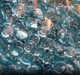 A video of a flame reflecting off the Aquamarine Tempered Fire Glass Gems