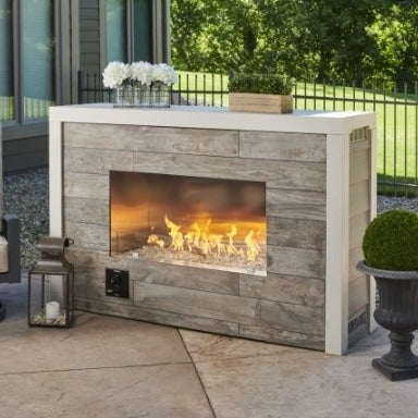 A single sided outdoor fireplace placed on an outdoor patio