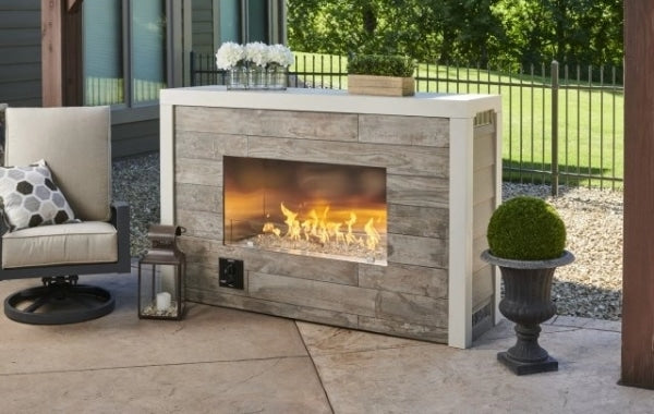 A single sided outdoor fireplace placed on an outdoor patio setup